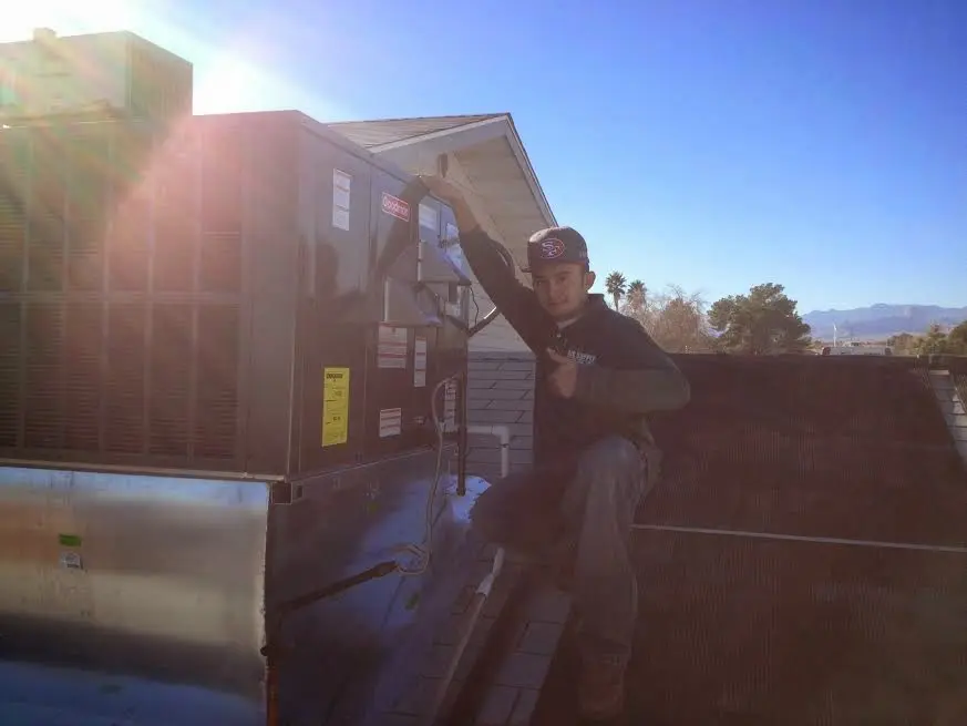 HVAC technician performing AC Tune-Up on a rooftop unit in Phillipsburg